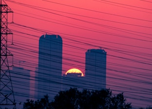 A striking visual of a fault line glowing with energy beneath a city skyline at dawn.
