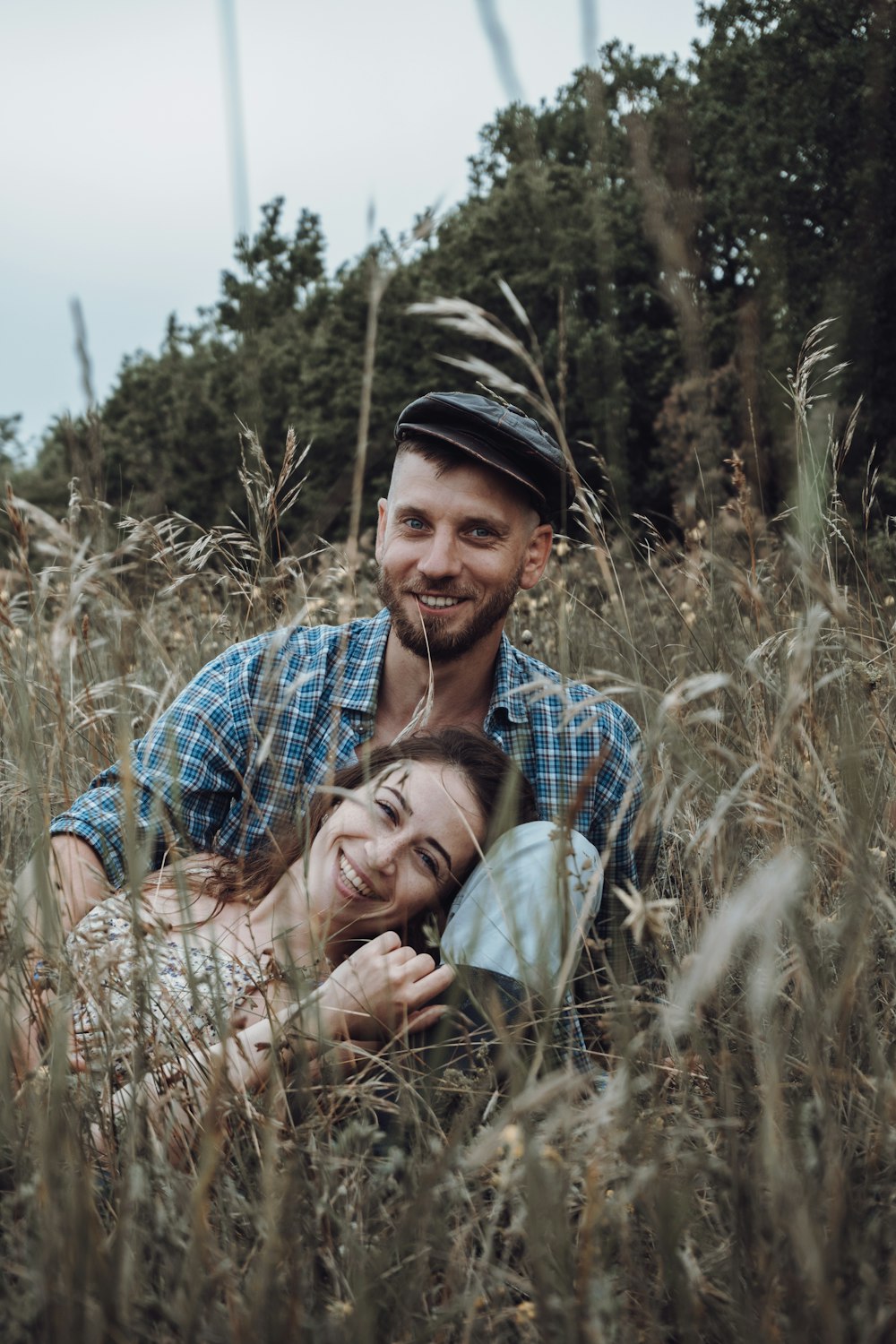 man in blue white and black plaid button up shirt carrying woman in brown and green