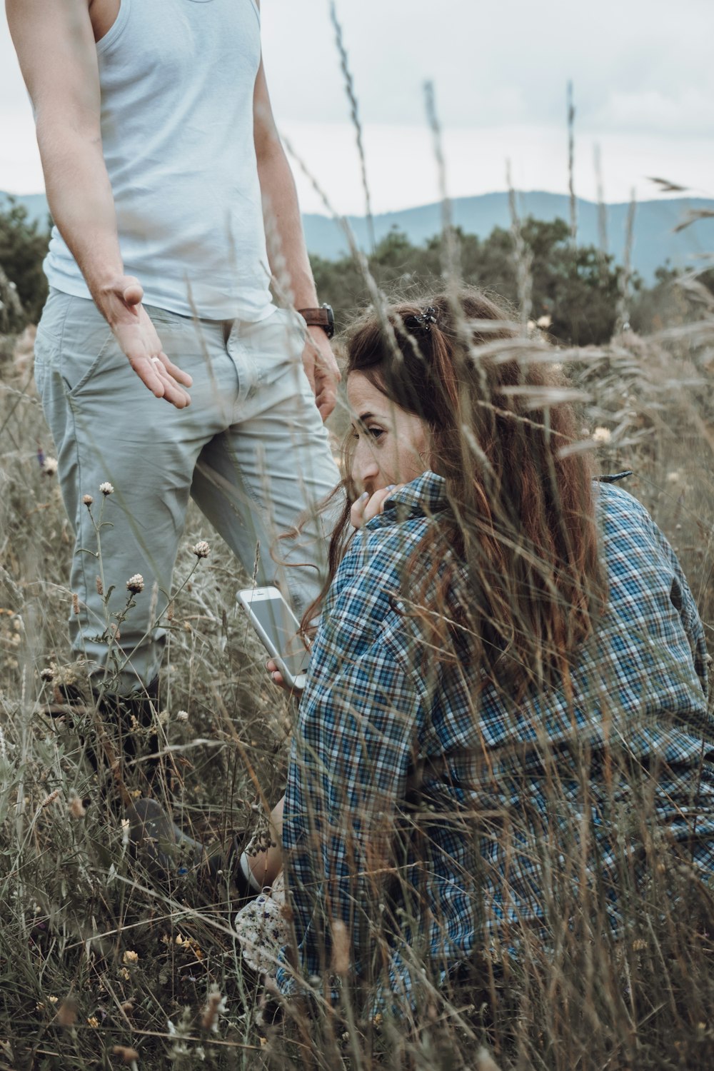 homme et femme s’embrassant sur le champ d’herbe brune pendant la journée