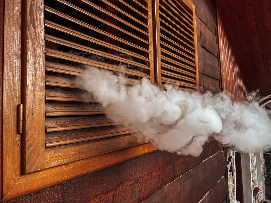 white smoke coming out from brown wooden window