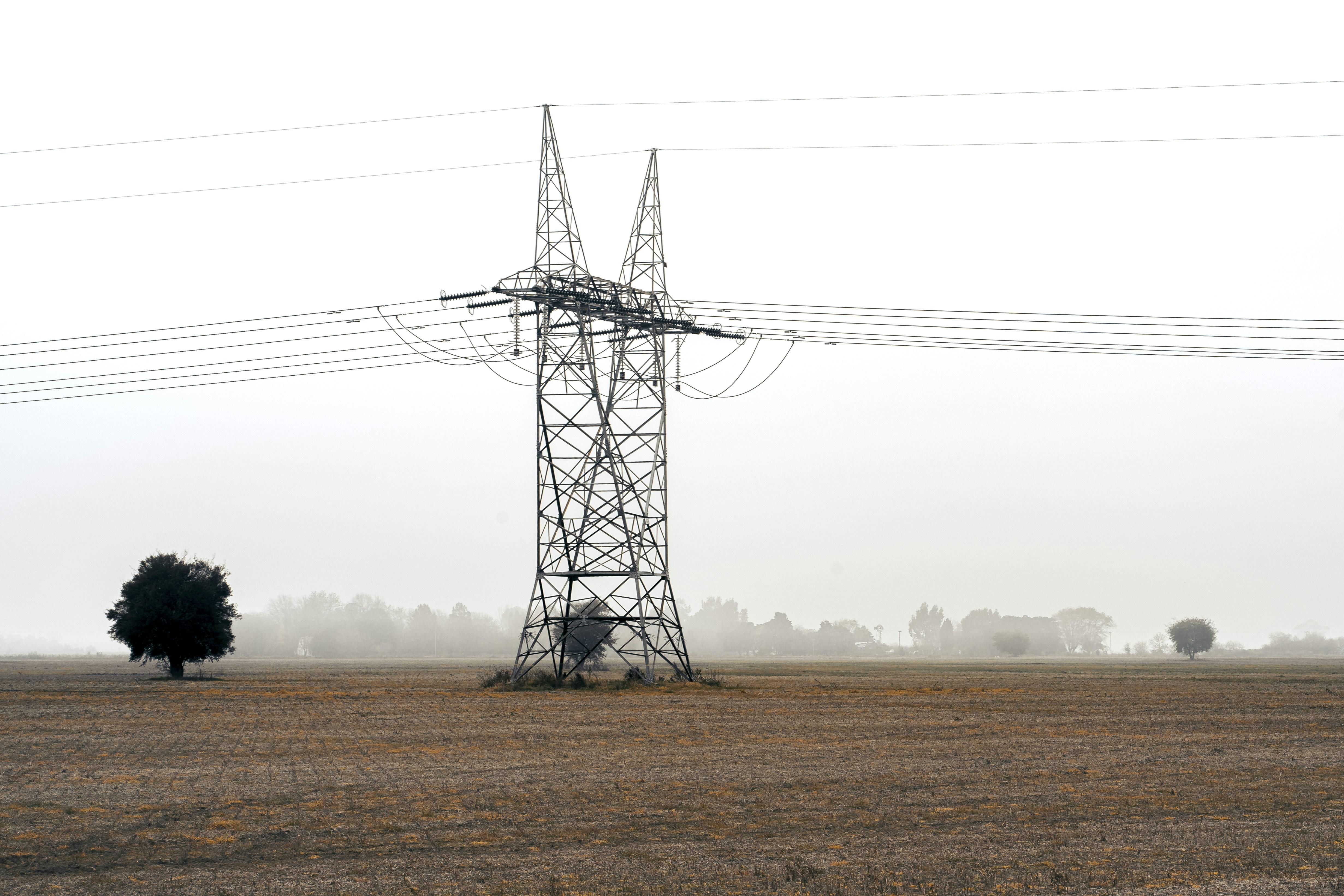 moinho de vento preto no campo marrom sob o céu branco durante o dia