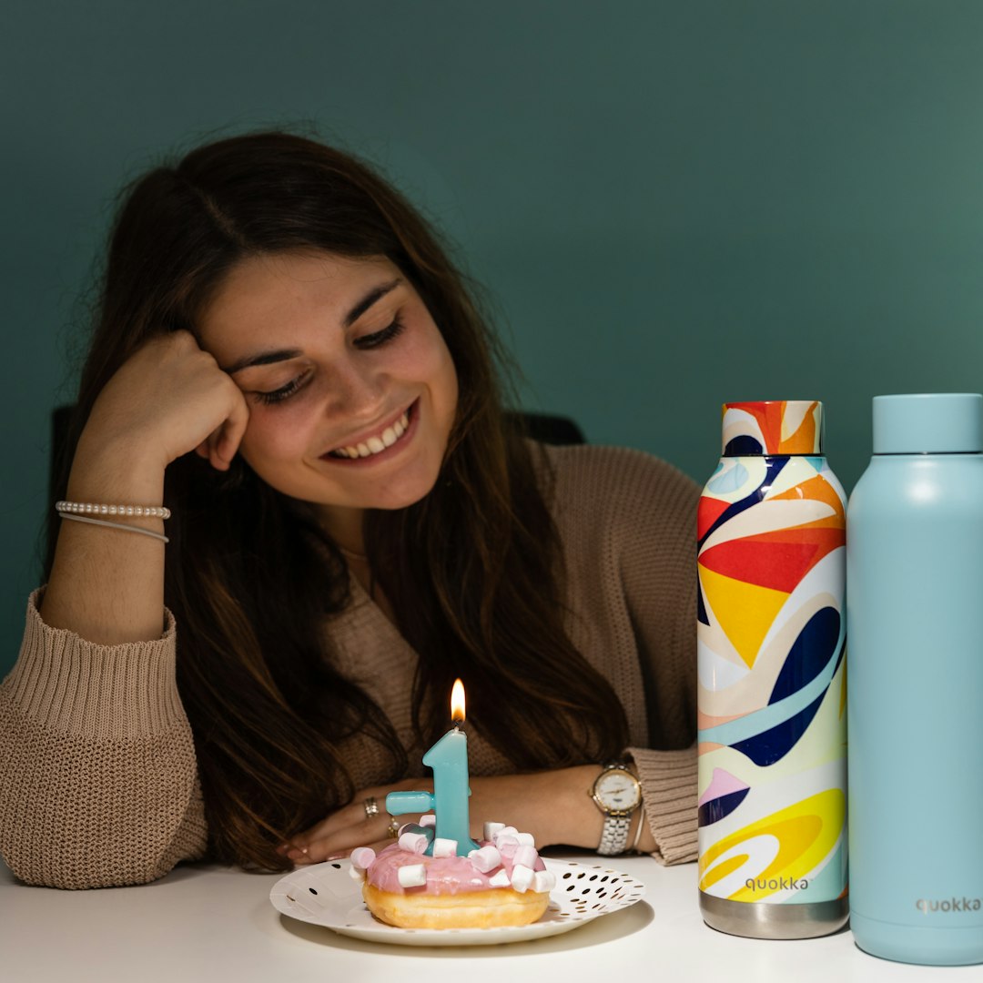 woman in black shirt holding white and blue can