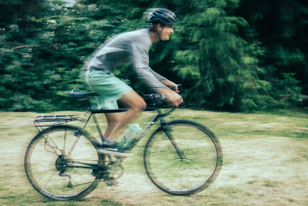 man in gray long sleeve shirt riding on bicycle