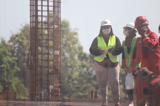 A diverse group of employees in safety gear collaborating on a construction site.