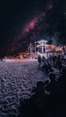 A beach scene featuring a movie screening under the stars.