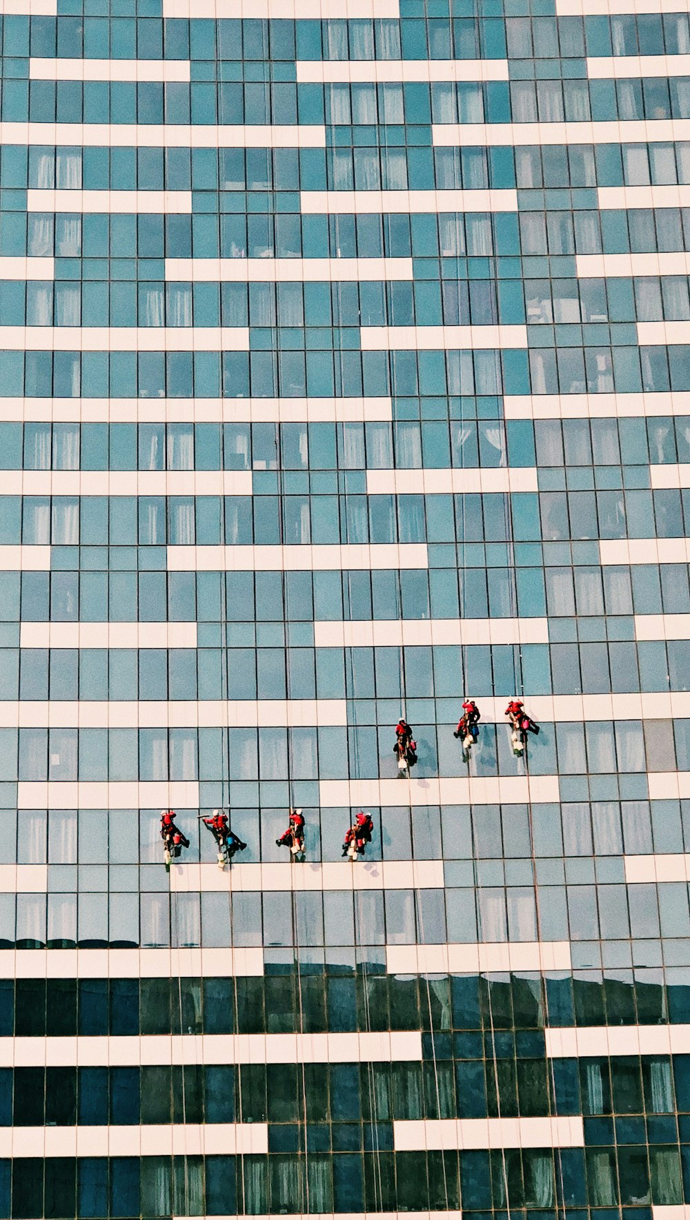 pessoas andando em um edifício de concreto azul e branco durante o dia