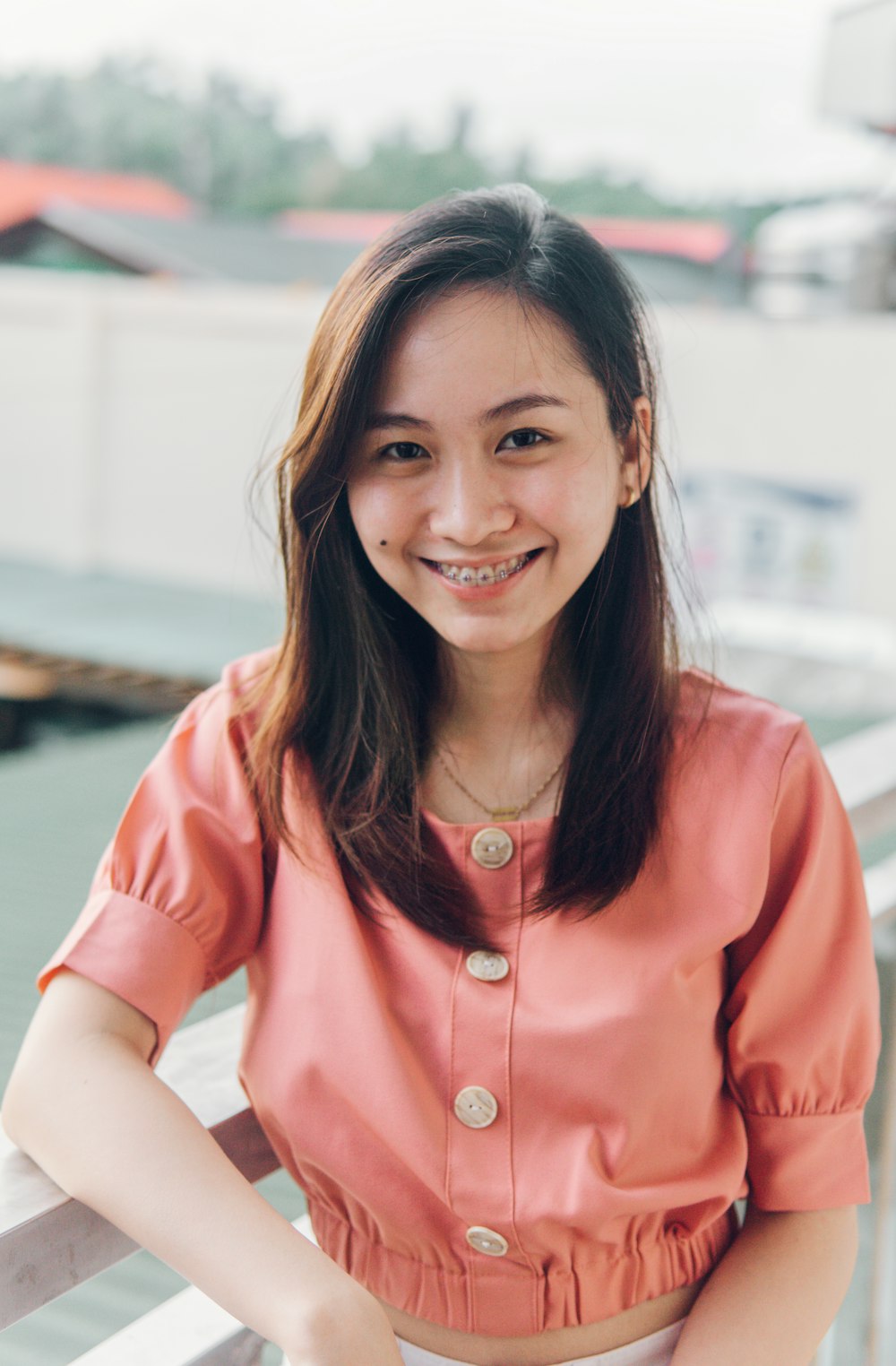 woman in pink button up long sleeve shirt smiling