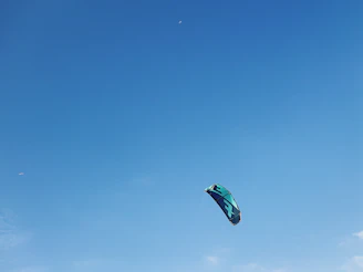 A vibrant close-up of a colorful Balaj Kite House kite soaring against a clear blue sky.