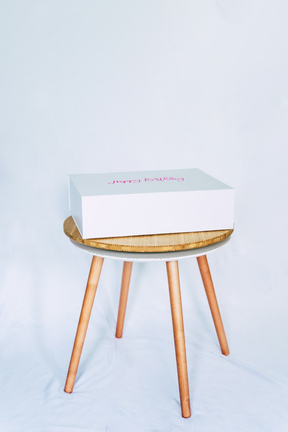 white box on brown wooden seat