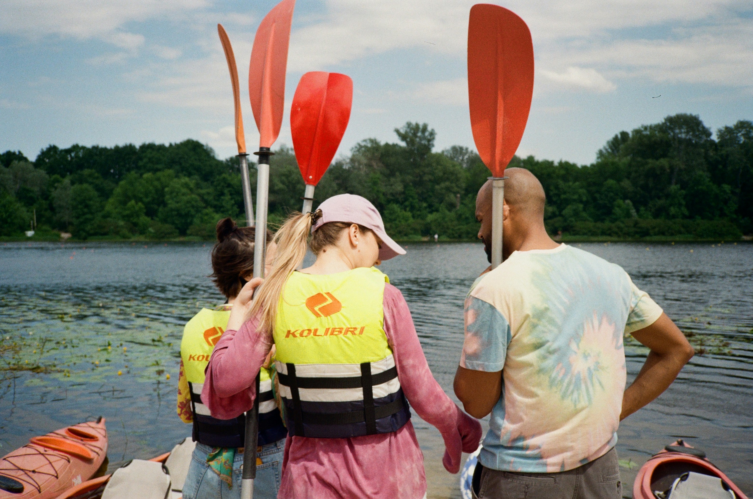 man and woman in white shirt and pink life vest holding hands while standing on body