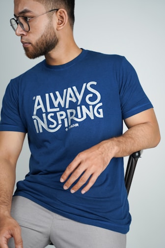 man in blue crew neck t-shirt sitting on black chair