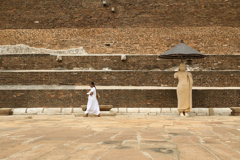 woman in white dress standing on brown concrete floor during daytime