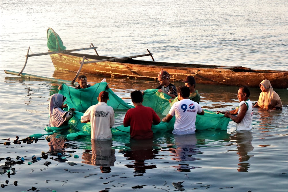 people in green boat on water during daytime