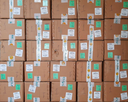 Hands of a professional carefully placing branded tape on a sturdy cardboard shipping box.