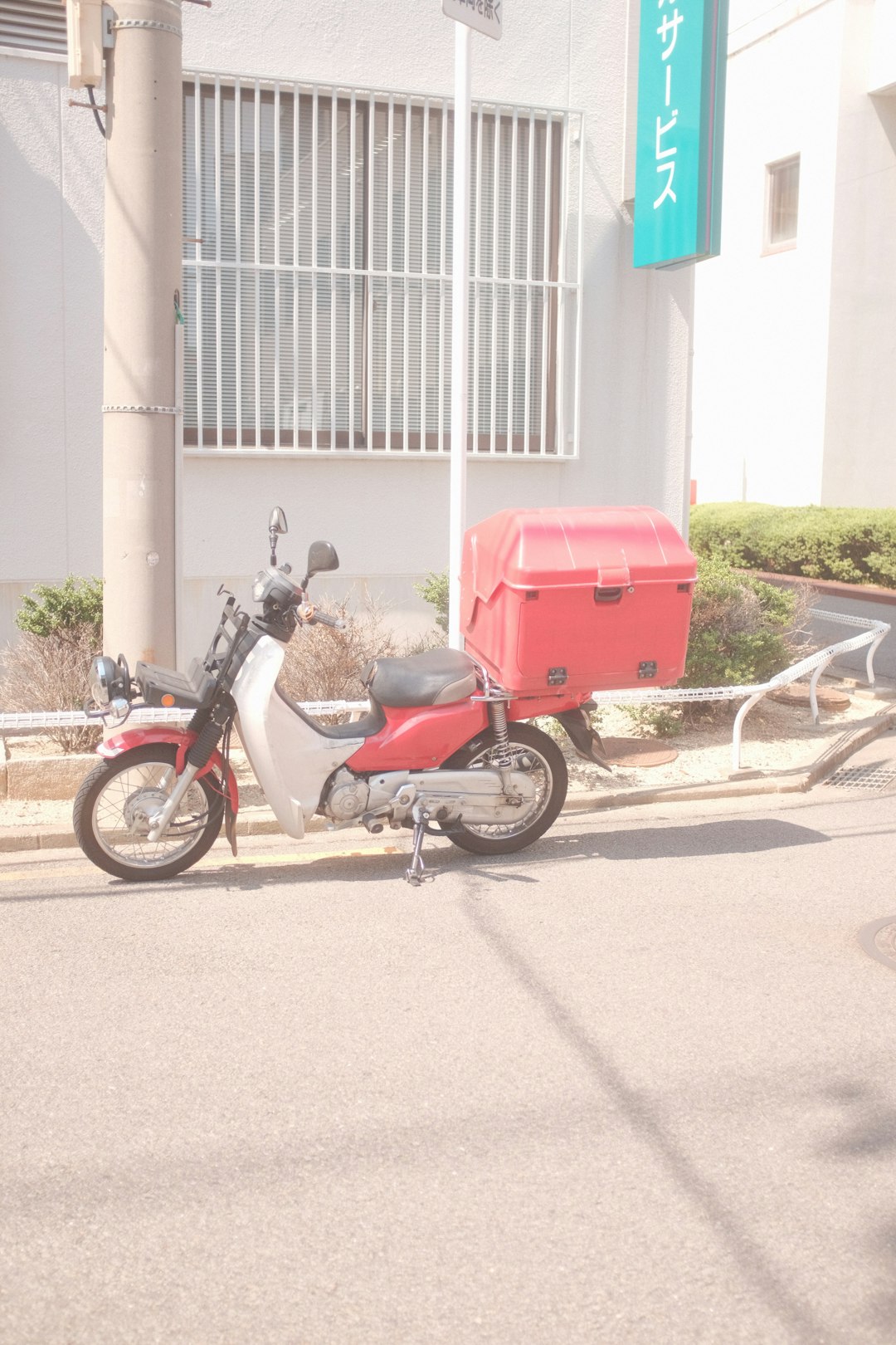 red and black motorcycle parked on gray concrete road during daytime