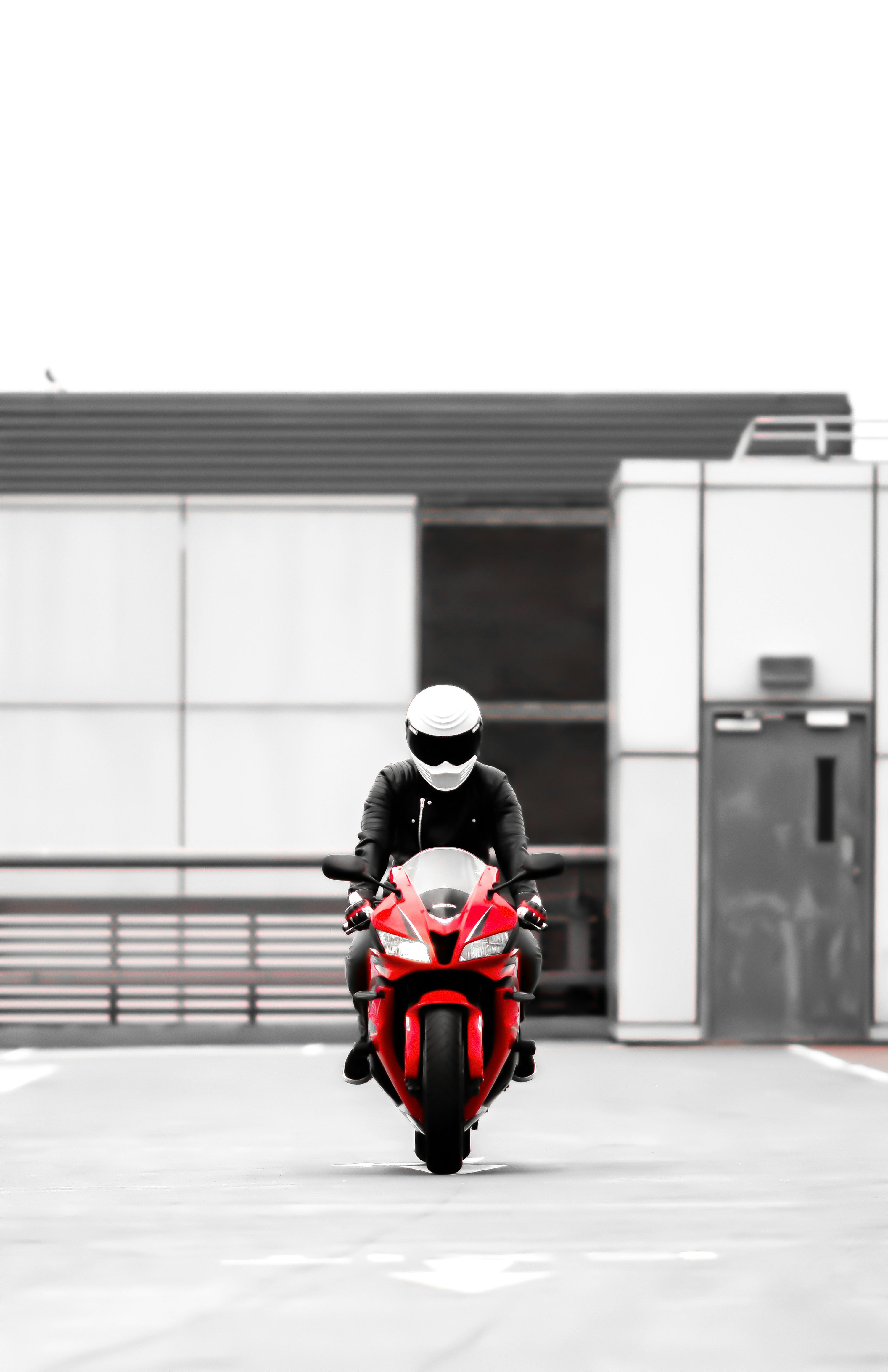 man in black jacket riding red motor scooter