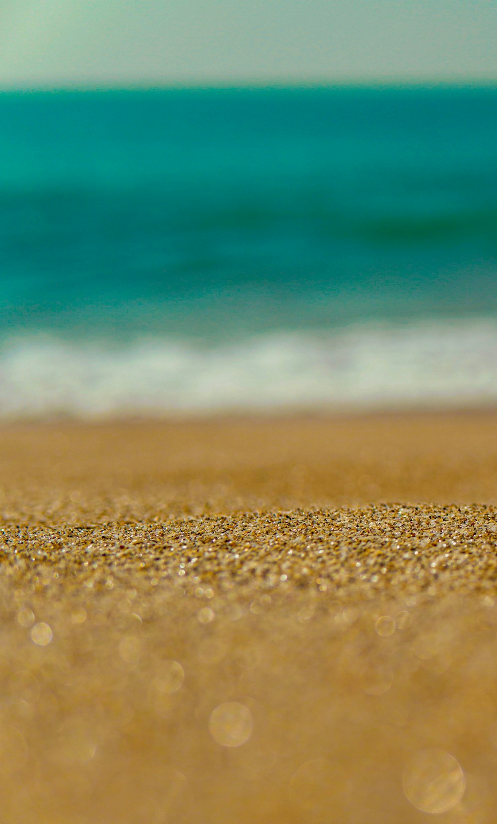 brown sand near body of water during daytime