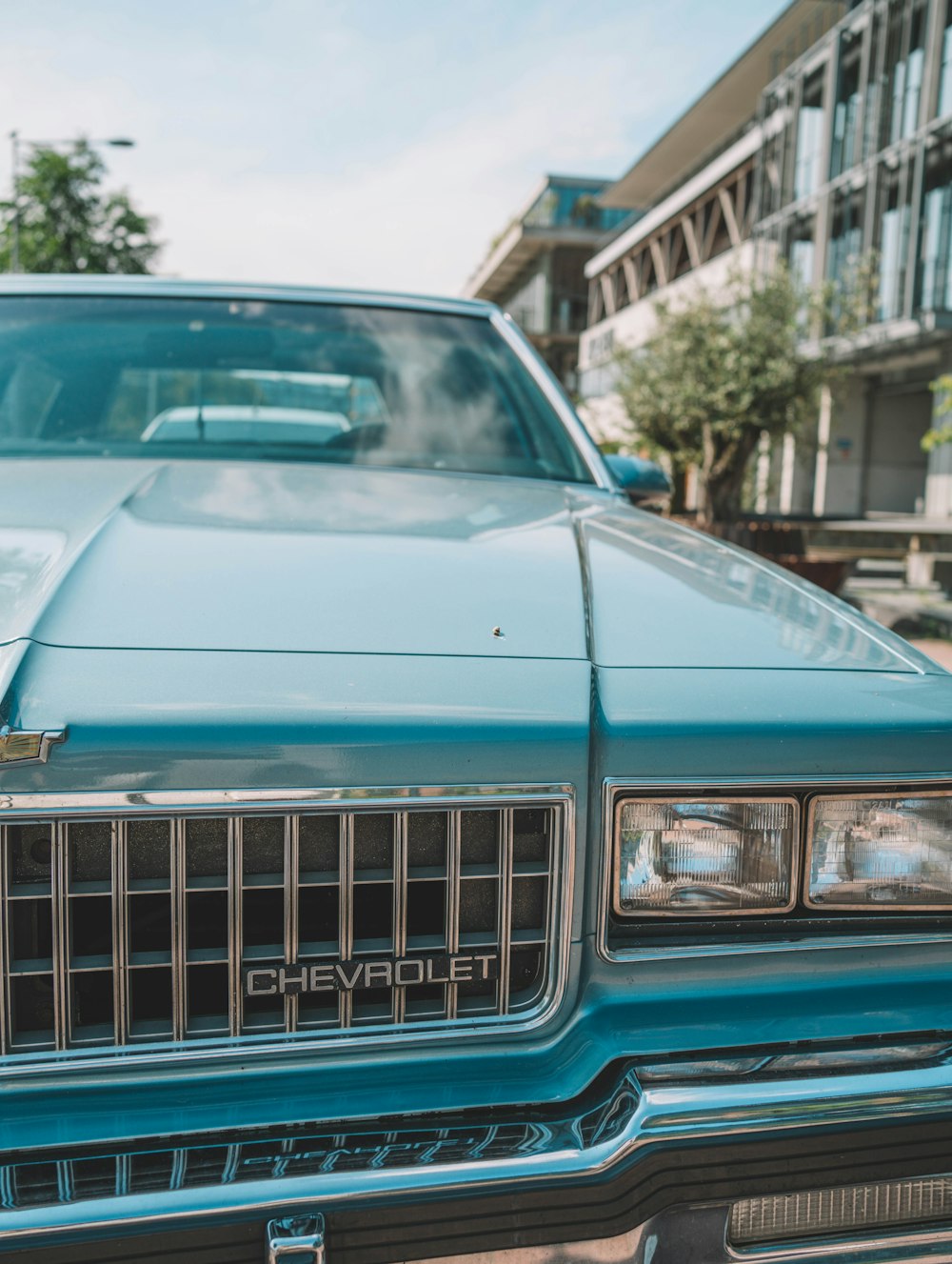 blue car in front of white building during daytime