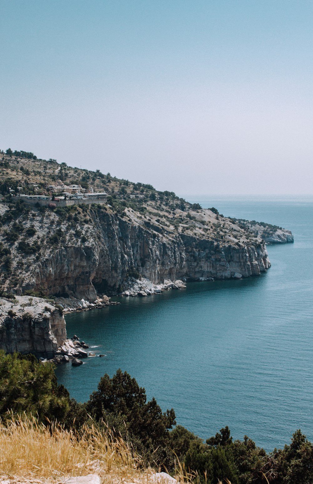 Montaña verde y marrón junto al mar azul durante el día