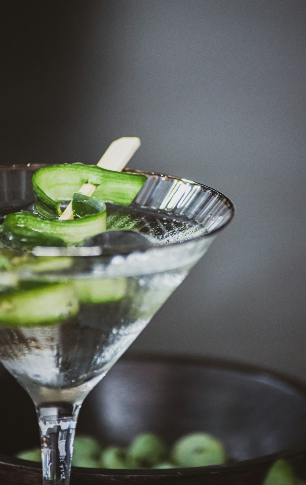 clear drinking glass with sliced lime and green leaf