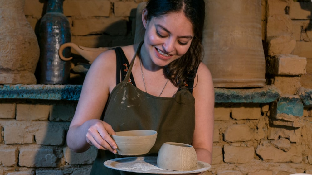 woman in black tank top holding white ceramic bowl