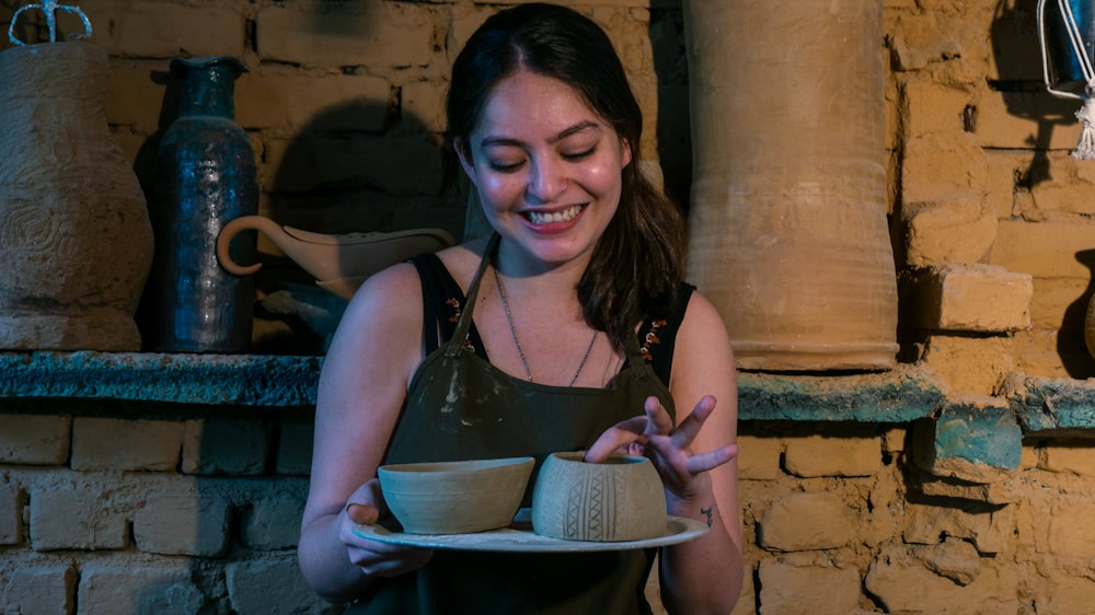 woman in black tank top holding white ceramic bowl