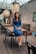 woman in blue long sleeve shirt sitting on brown wooden chair