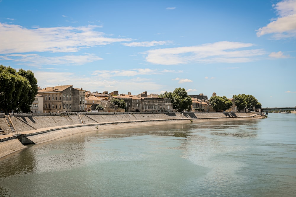 Edificio in cemento marrone vicino allo specchio d'acqua sotto il cielo blu durante il giorno