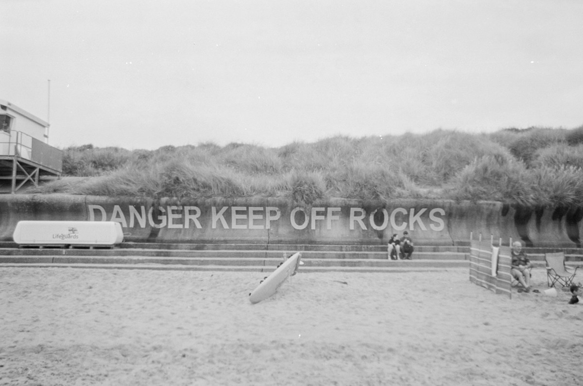 Students rehearsing on stage for a high school musical, with scripts in hand and a director giving notes from the front row