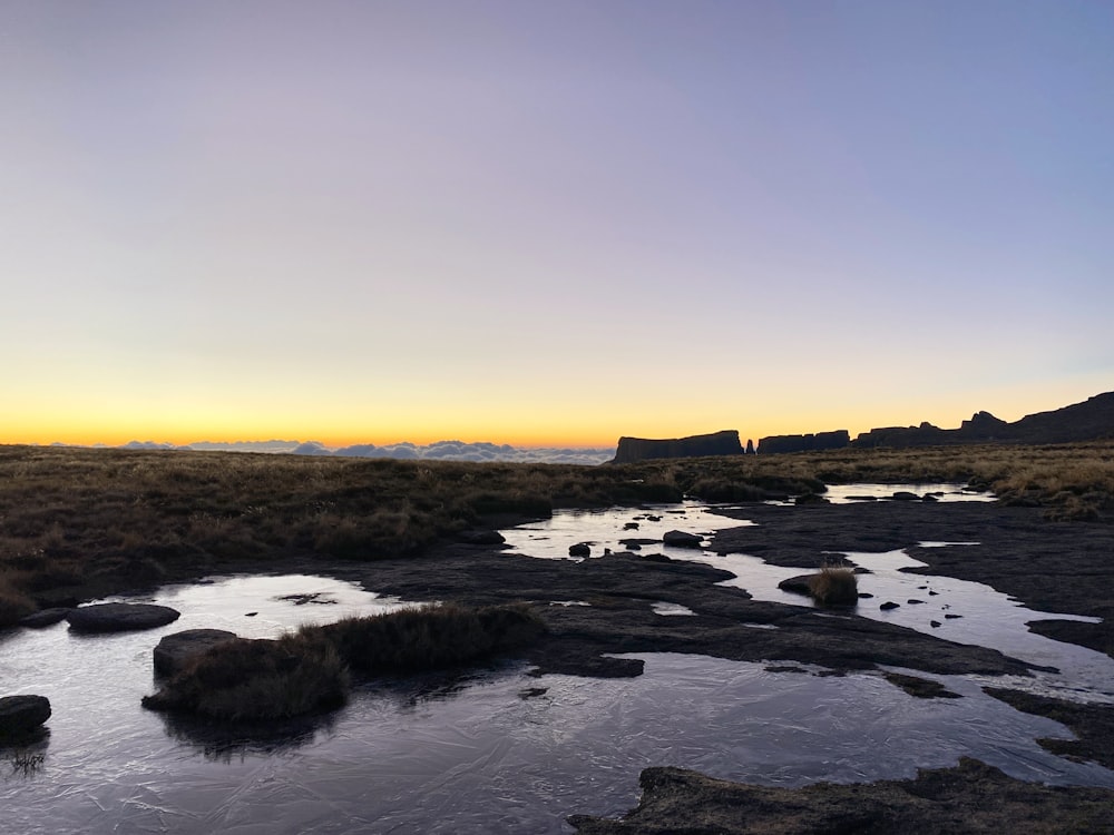 Cuerpo de agua cerca de rocas durante el día