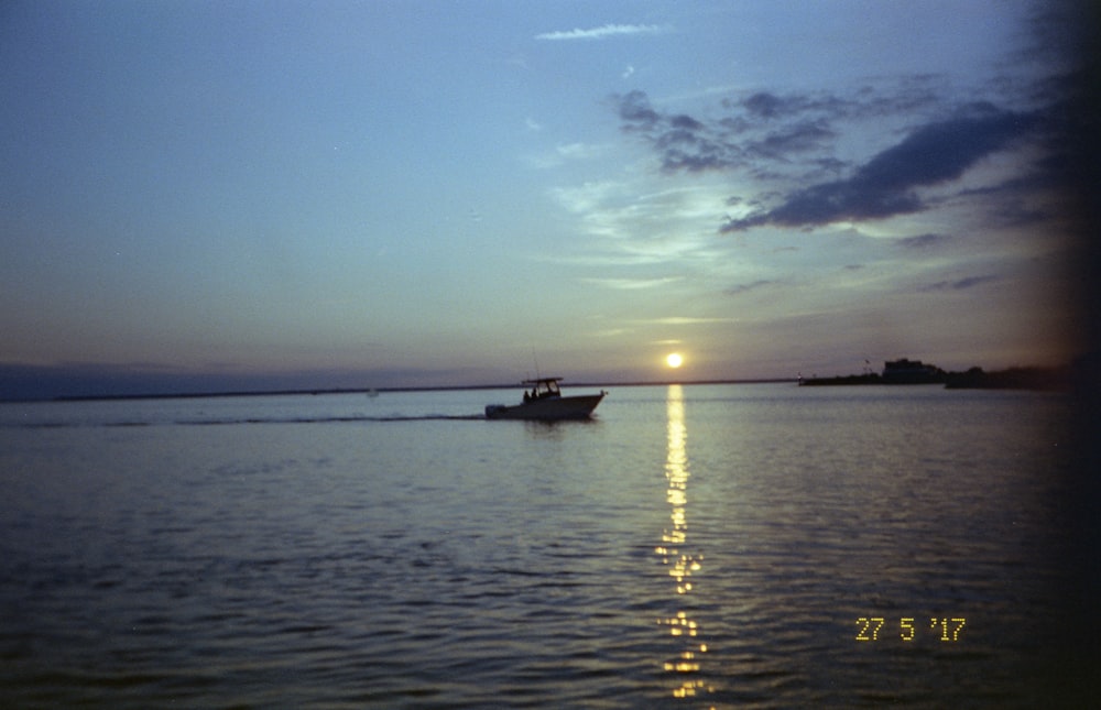 boat on sea under blue sky during daytime