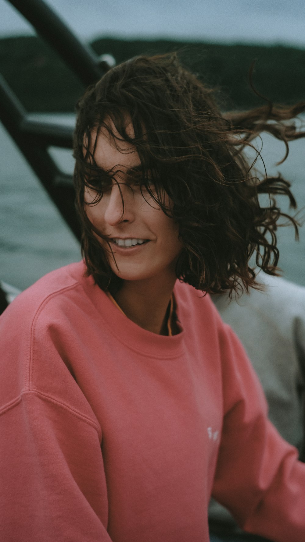 mulher sorridente na camisa rosa do pescoço da tripulação