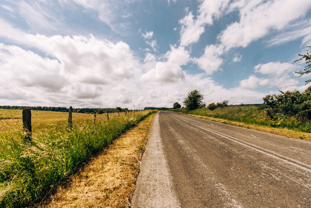 green grass field under white clouds during daytime