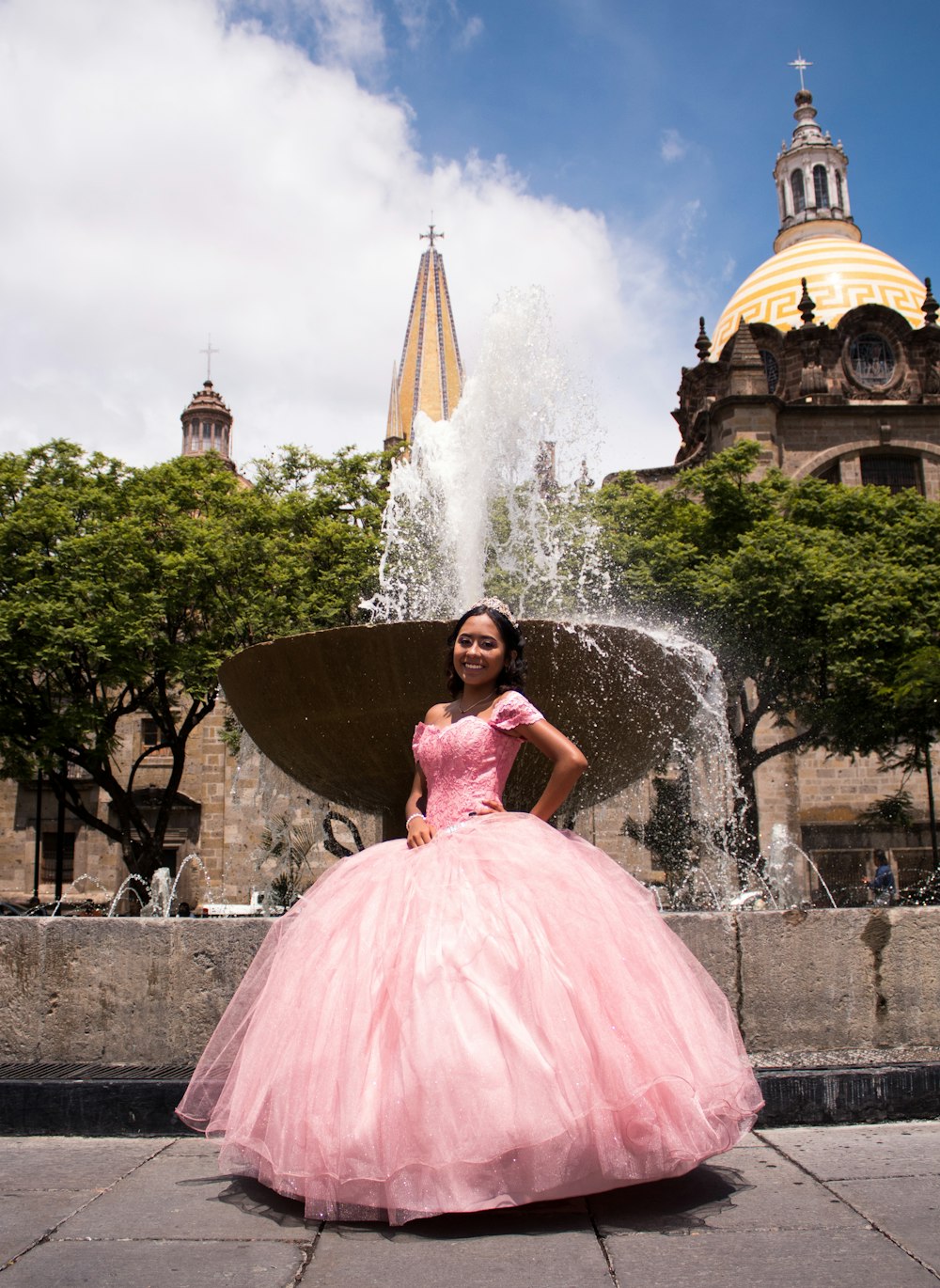 woman in pink dress standing on fountain