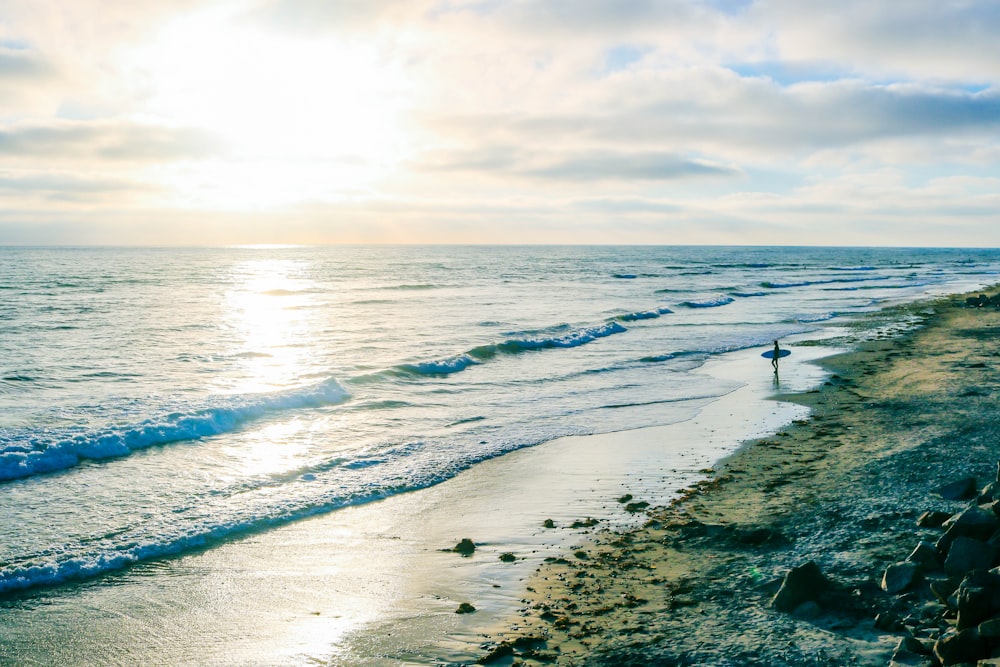 person walking on beach during daytime