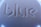 The image displays a close-up view of a surface with the word 'blue' embossed in a modern, geometric font style. The texture appears smooth with a play of light and shadow enhancing the three-dimensional effect of the lettering.