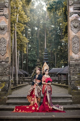 woman in red and white traditional dress standing on gray concrete stairs