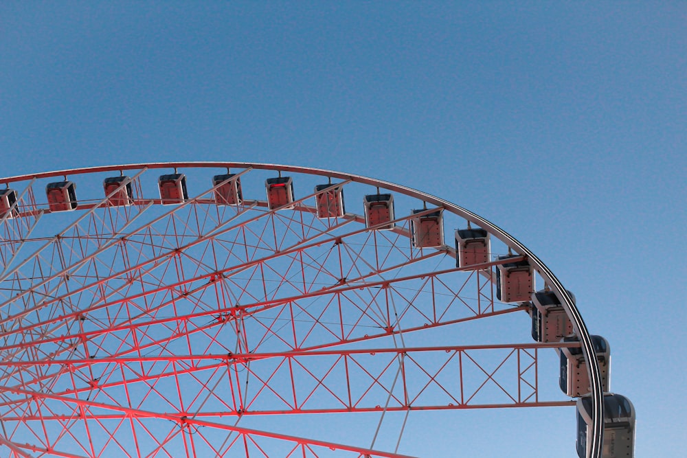 roda gigante branca e vermelha sob o céu azul durante o dia