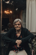 woman in black and gray sweater wearing eyeglasses