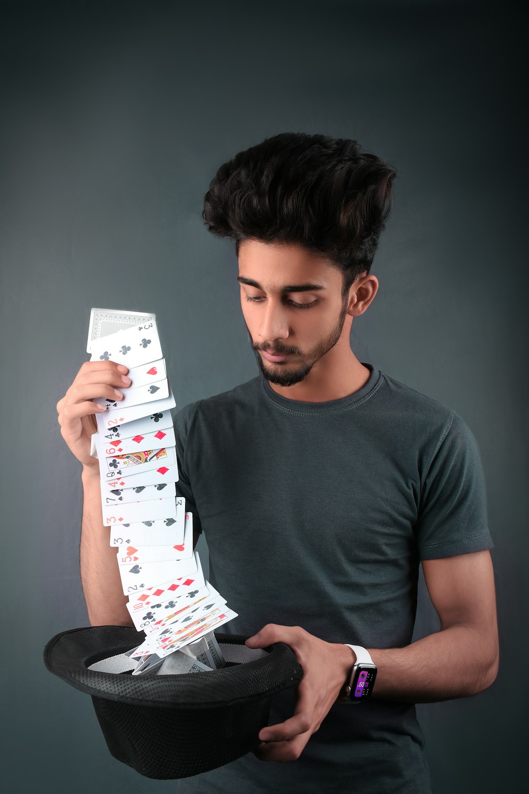 man in gray crew neck t-shirt holding white and red playing cards