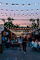 people sitting on chairs near brown wooden building during night time