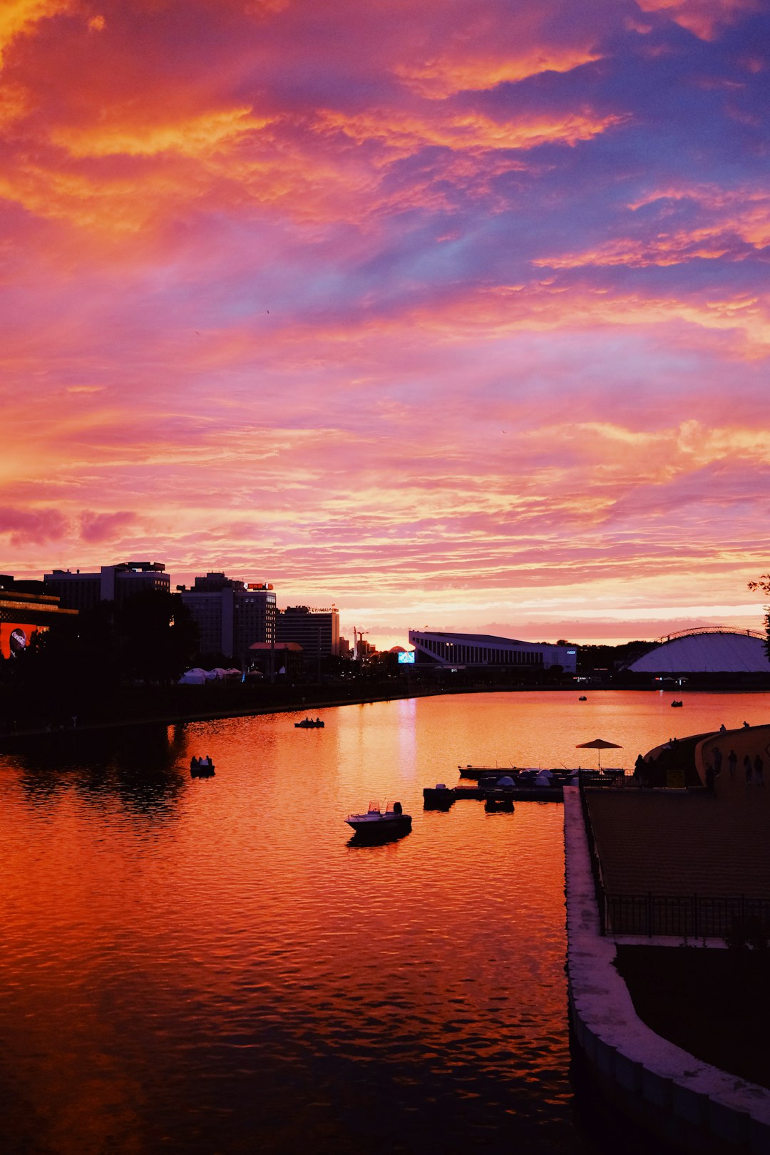 silhouette of buildings near body of water during sunset