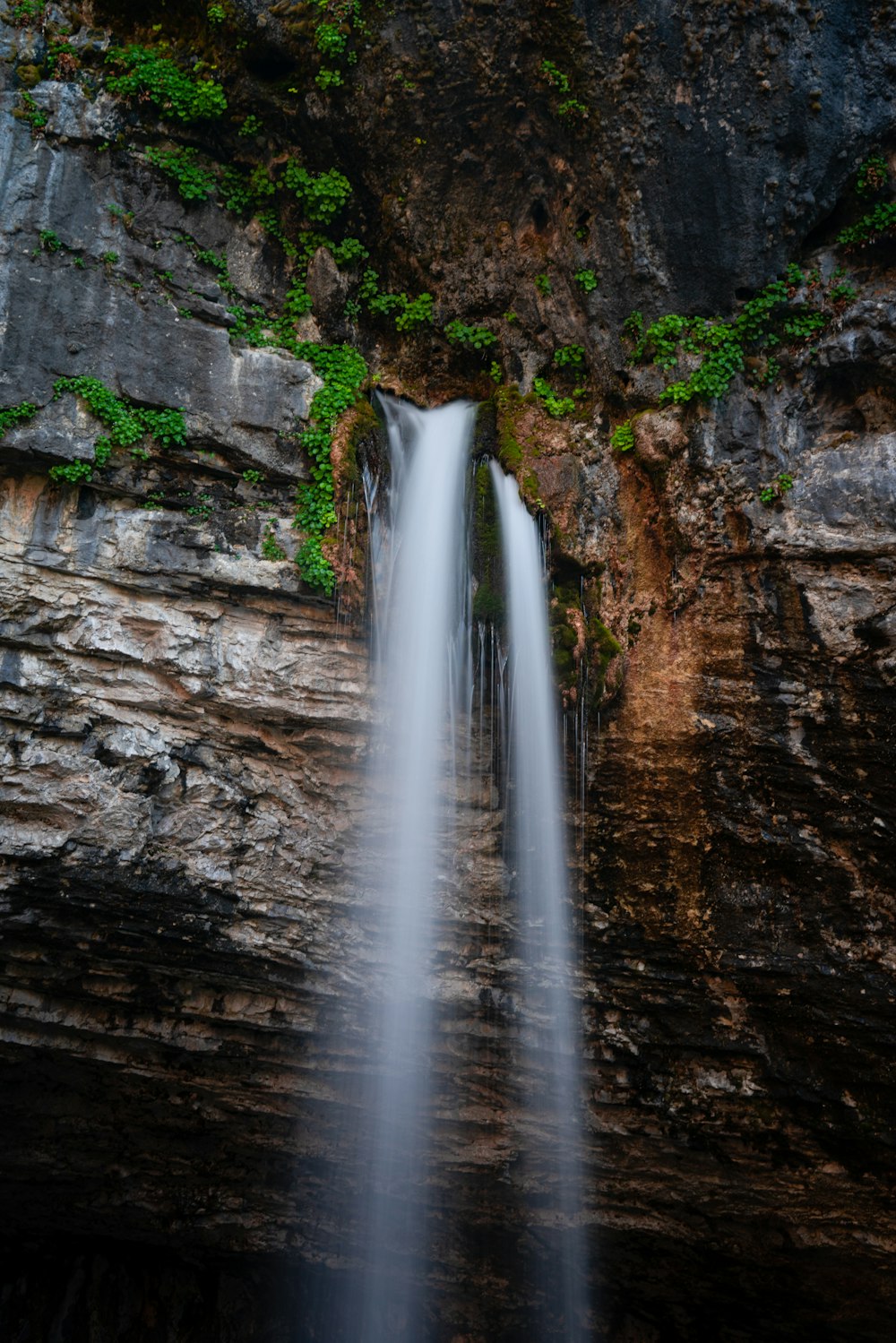 water falls on brown rocky mountain