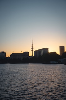 An aerial view of a city skyline at dusk with radio towers glowing