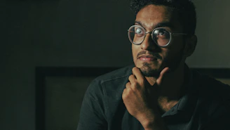 man in black framed eyeglasses and black long sleeve shirt