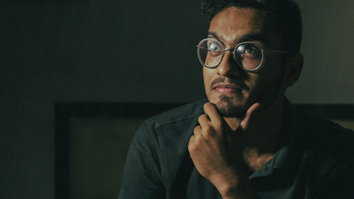 man in black framed eyeglasses and black long sleeve shirt