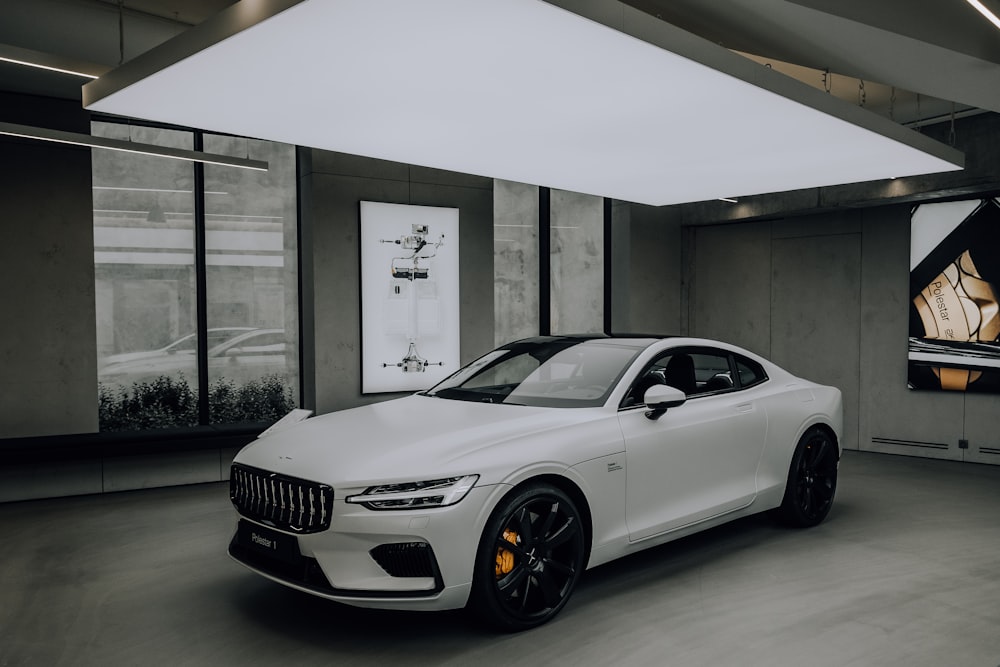 white bmw m 3 coupe parked in front of white building