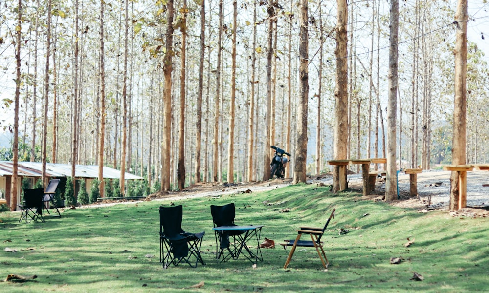 black metal chairs and table on green grass field