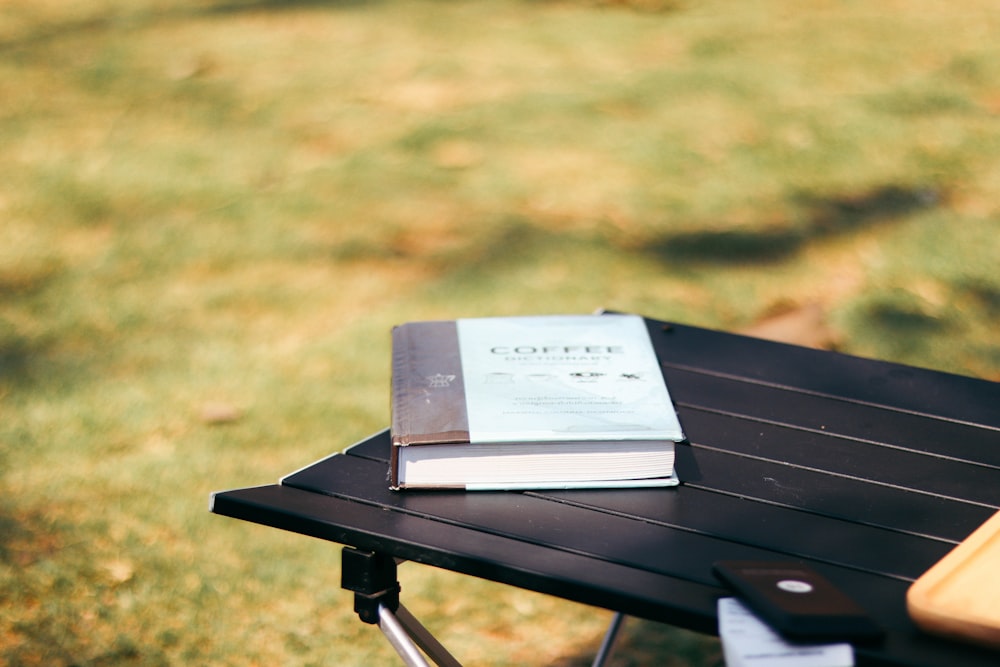 white book on black wooden table