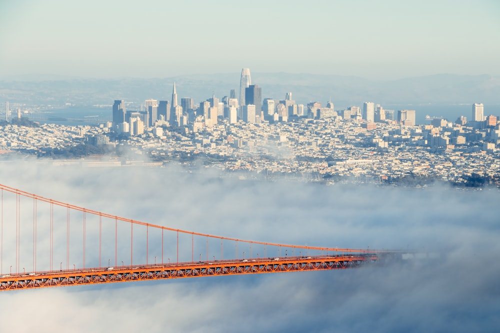 red bridge over city skyline during daytime